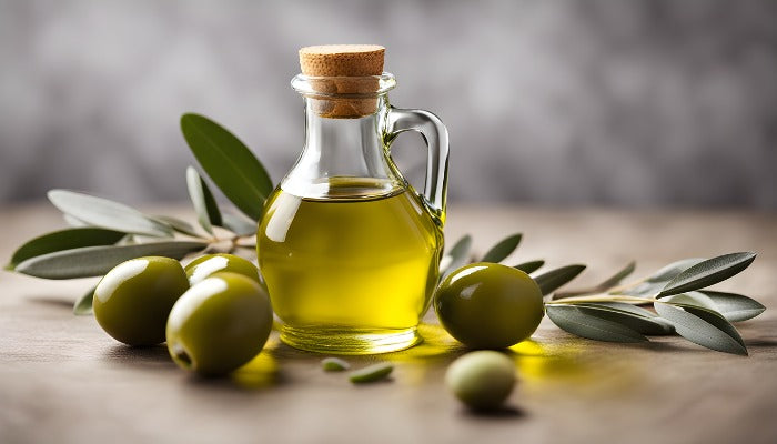Olive Oil in a glass bottle on a platform with olives and olive leaves by the side