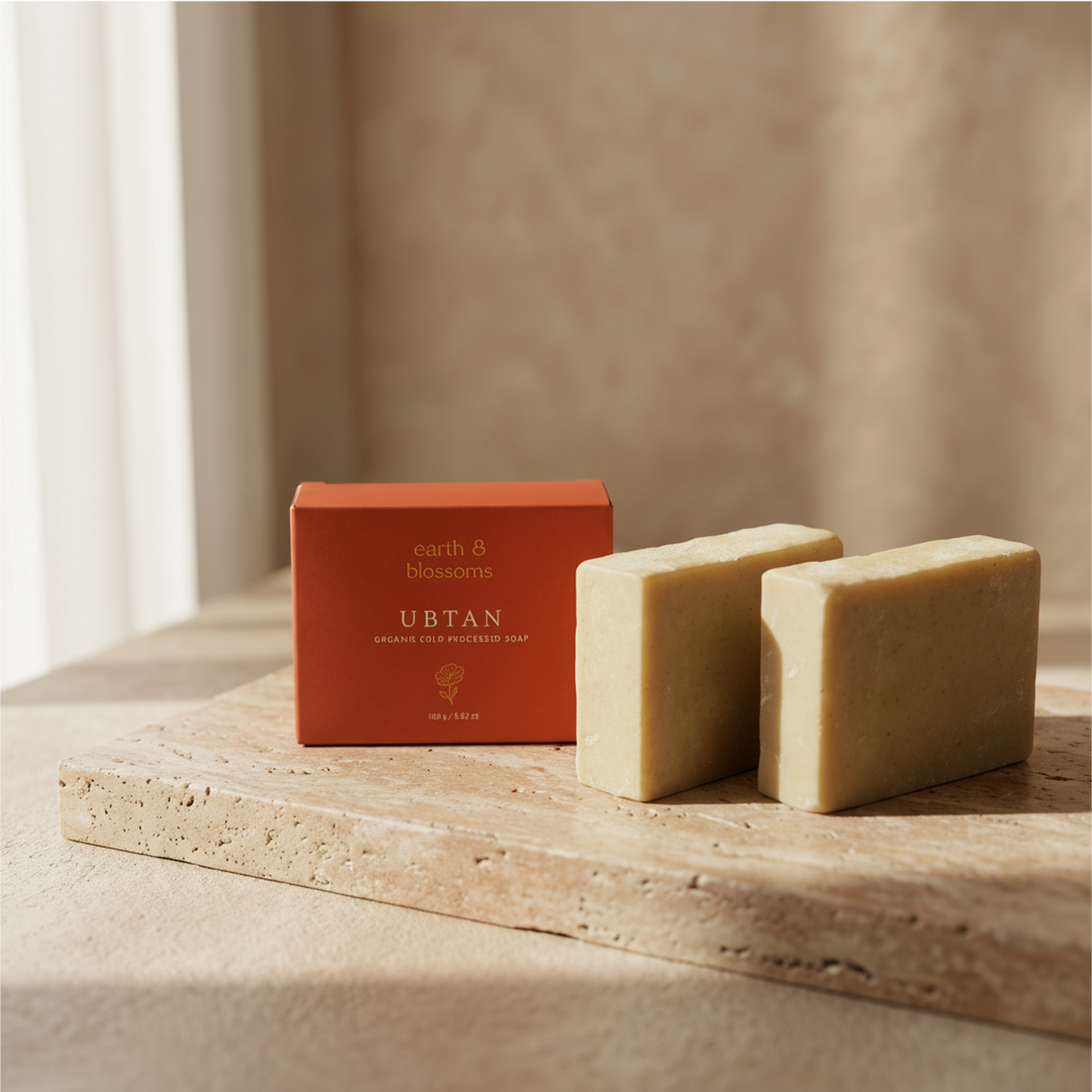 Two bars of soap and a red box labeled 'UBTAN' on a wooden surface with a neutral background.